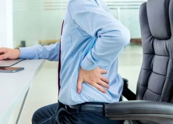 What spinal problems can sitting for long periods of time cause?