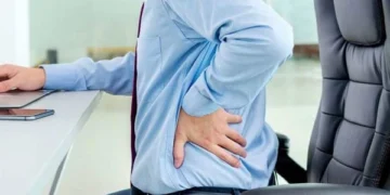What spinal problems can sitting for long periods of time cause?